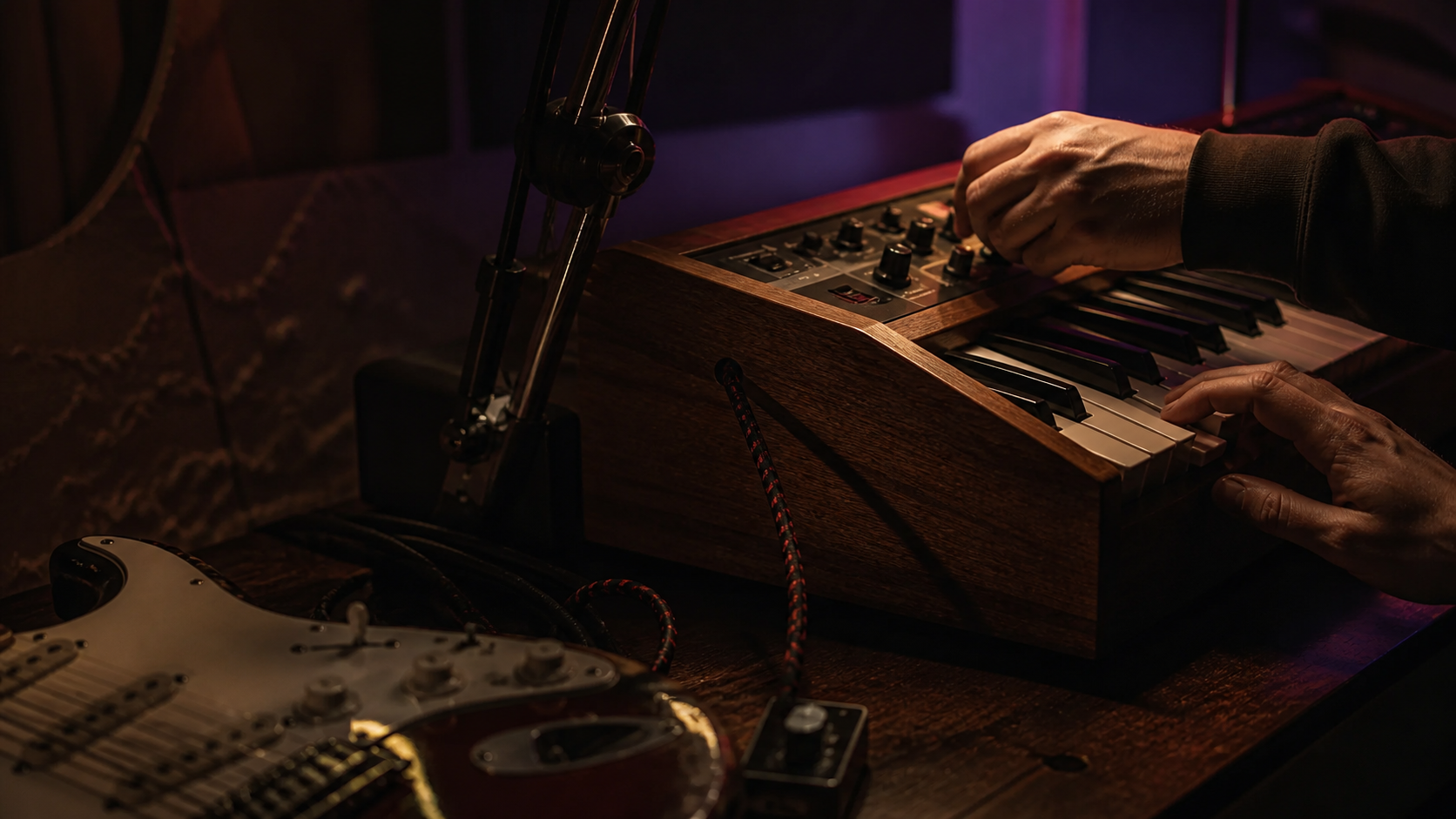 Hands shaping sound at a keyboard and synthesizer
